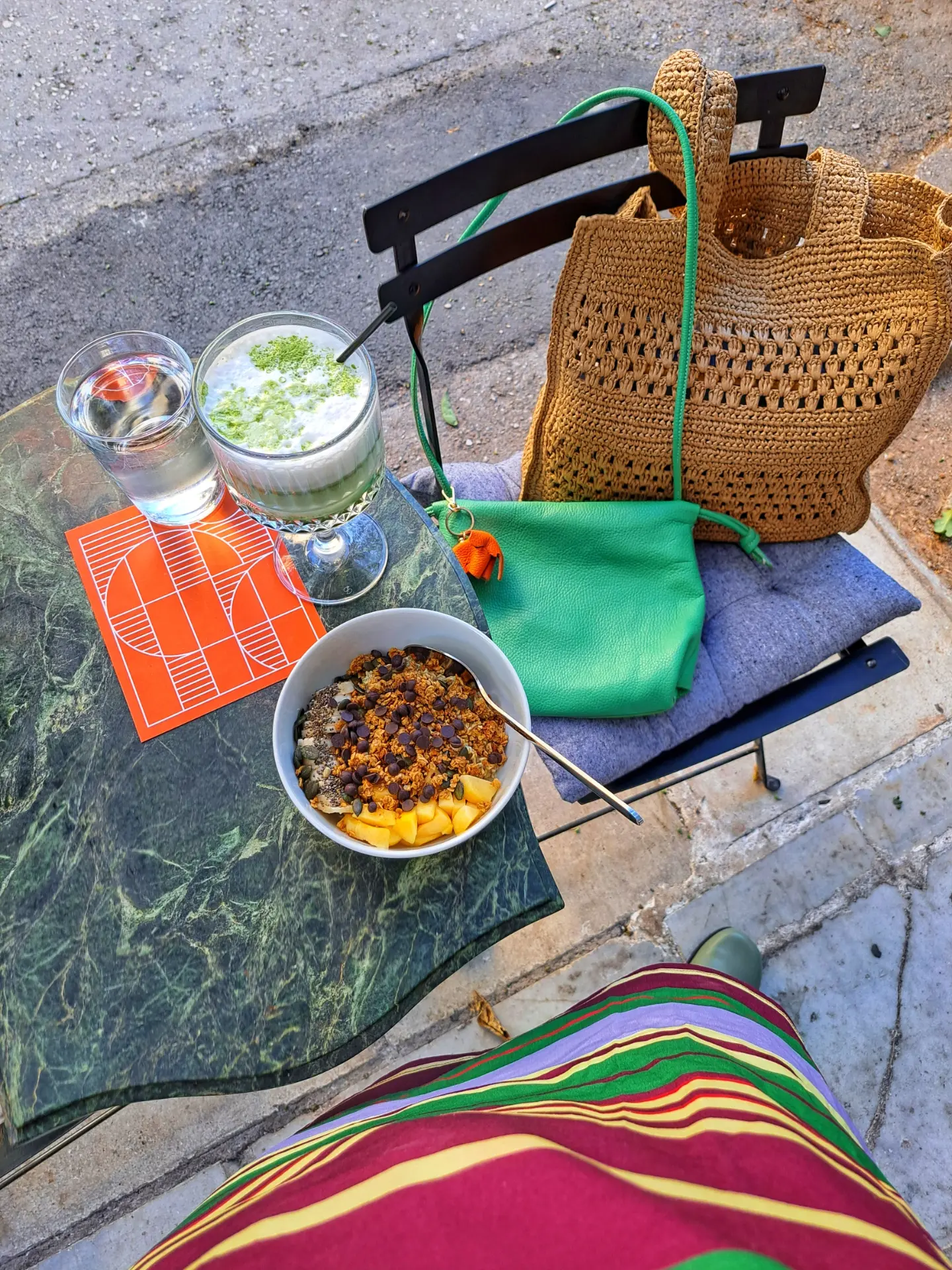Matcha, a granola bowl and a sketchbook on the outdoor table